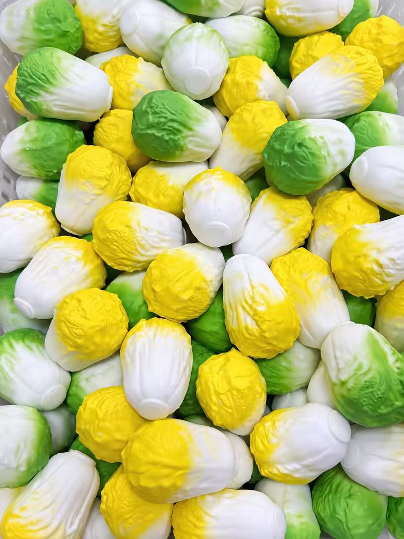 Crunchy Cabbage Squishy - yellow variant being squished with both thumbs