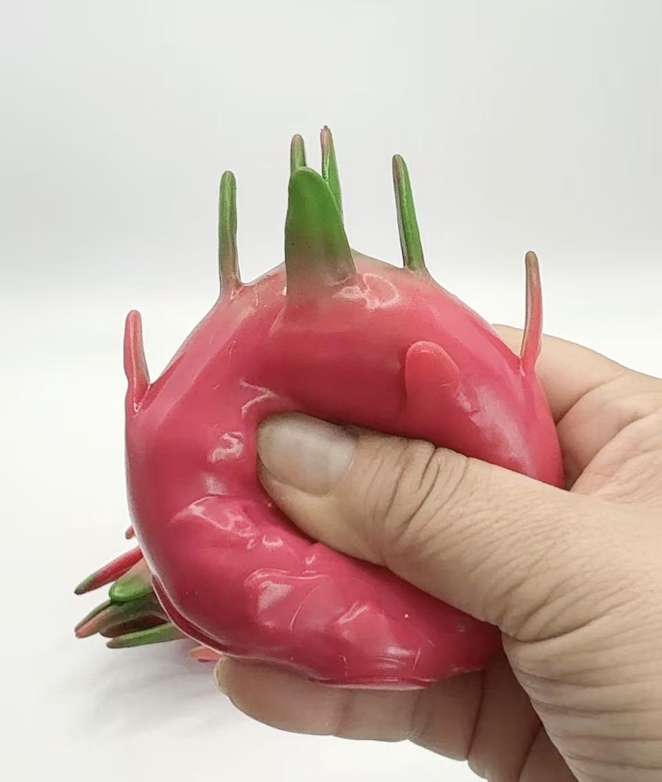 Dragon Fruit Squishy being squeezed with one hand - showing deformation