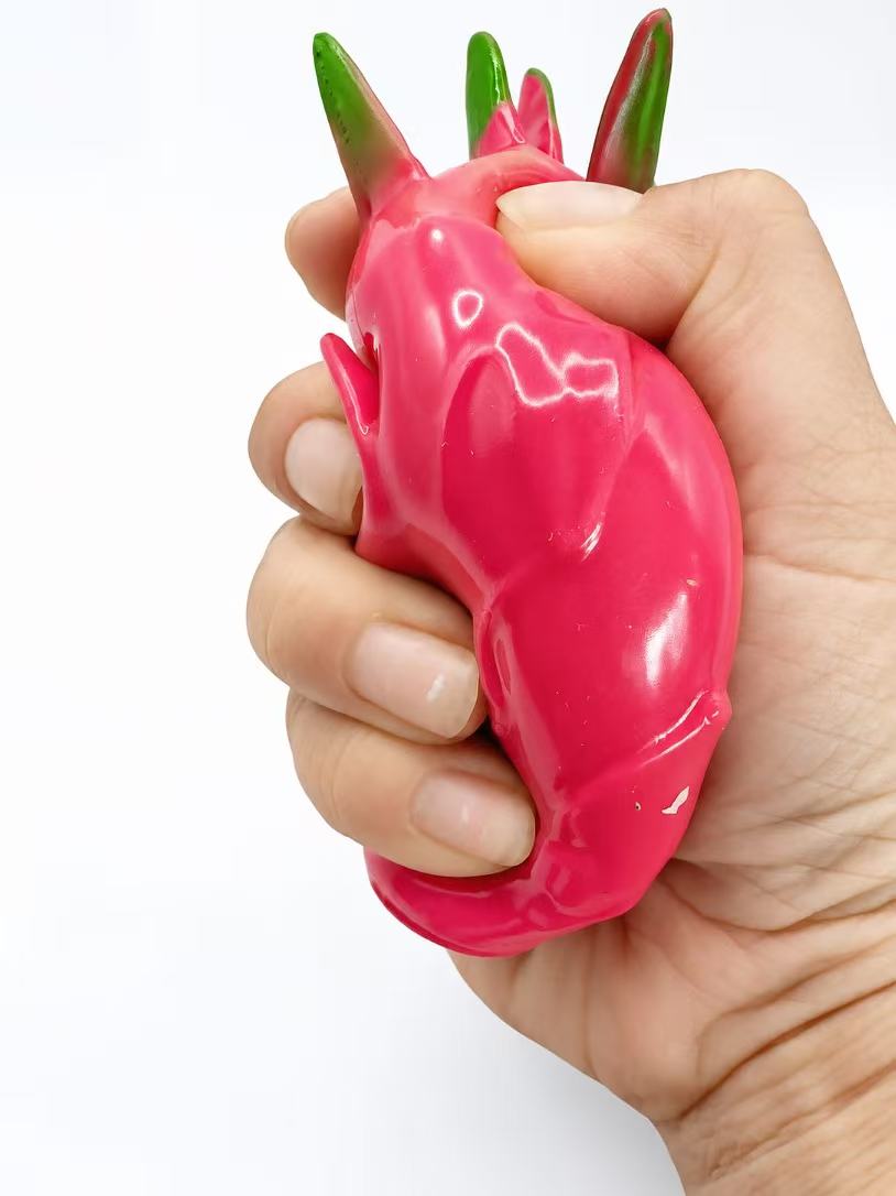 Dragon Fruit Squishy squeezed in fist - side view